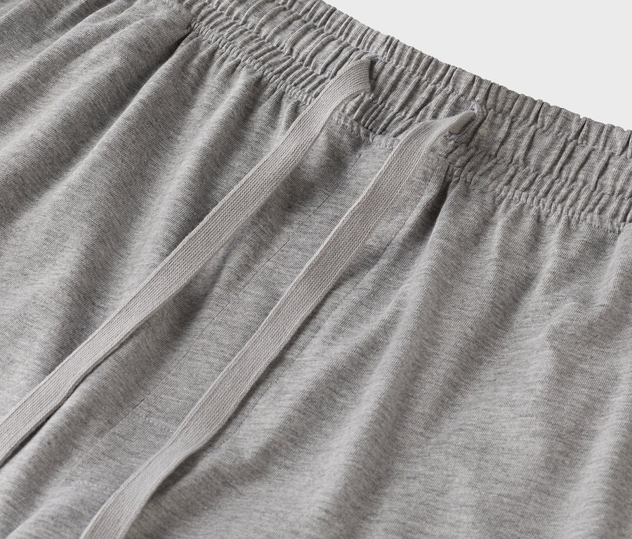 Detail sivých teplákov so šnúrkou.