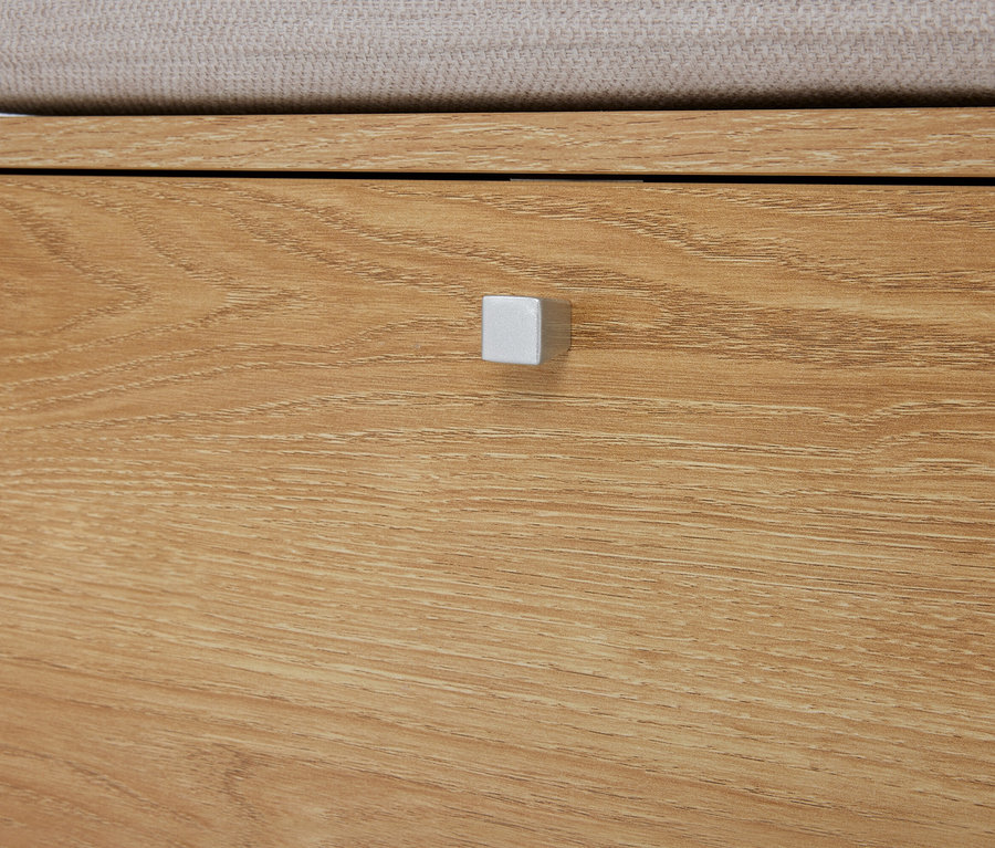 Detailný záber na svetlohnedú drevenú komodu so zásuvkou a striebornou štvorcovou úchytkou.