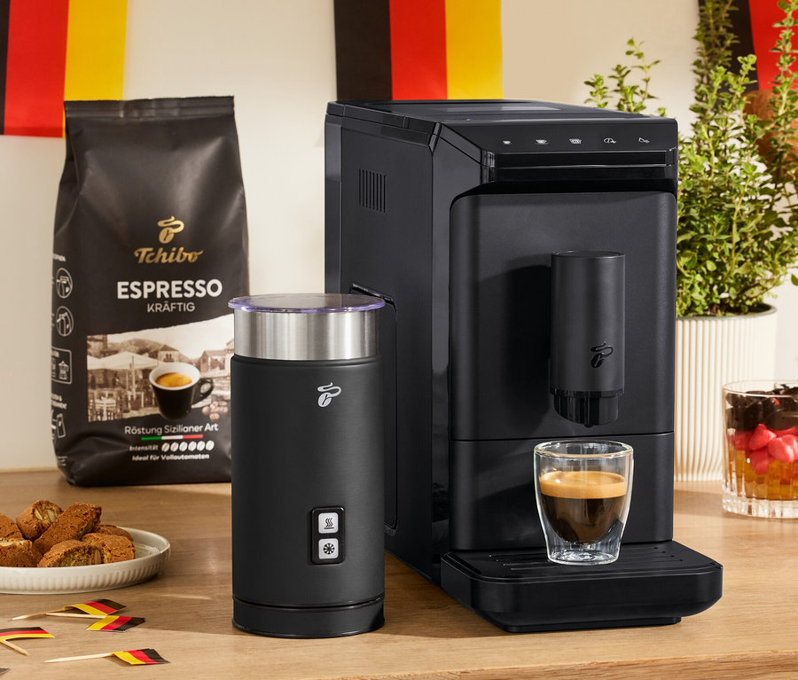 Na stole stojí »Esperto mini« plnoautomatický kávovar, čierny elektrický napeňovač mlieka a 2 dvojstenné poháre na espresso.
