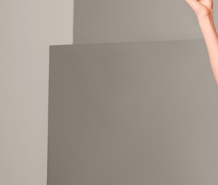 Žena pózuje v červenom tričku a tmavomodrých bermudách.