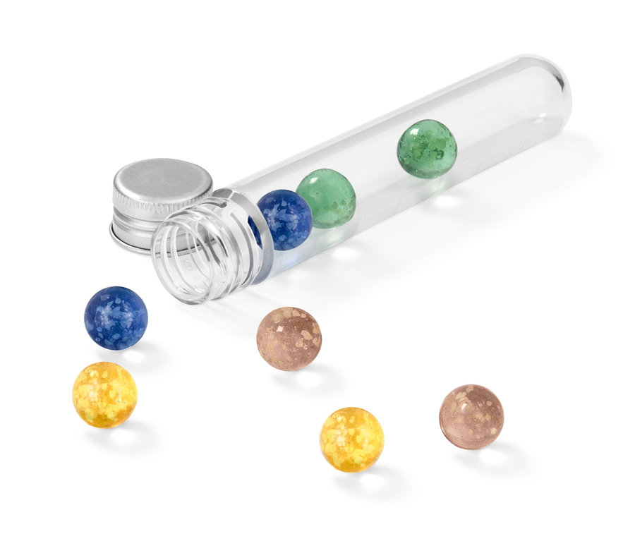 Priehľadná skúmavka leží na boku a obsahuje svetelné guľôčky rôznych farieb, ďalšie guľôčky sú rozsypané vedľa.