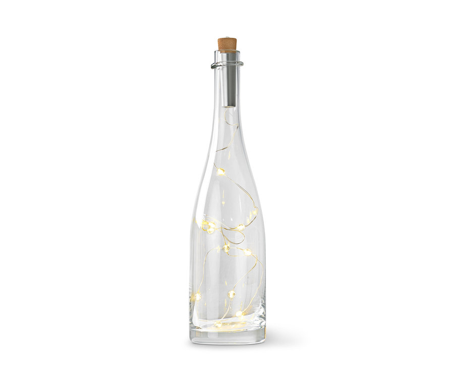 Číra sklenená fľaša s korkovou zátkou a svetelnou reťazou vnútri.
