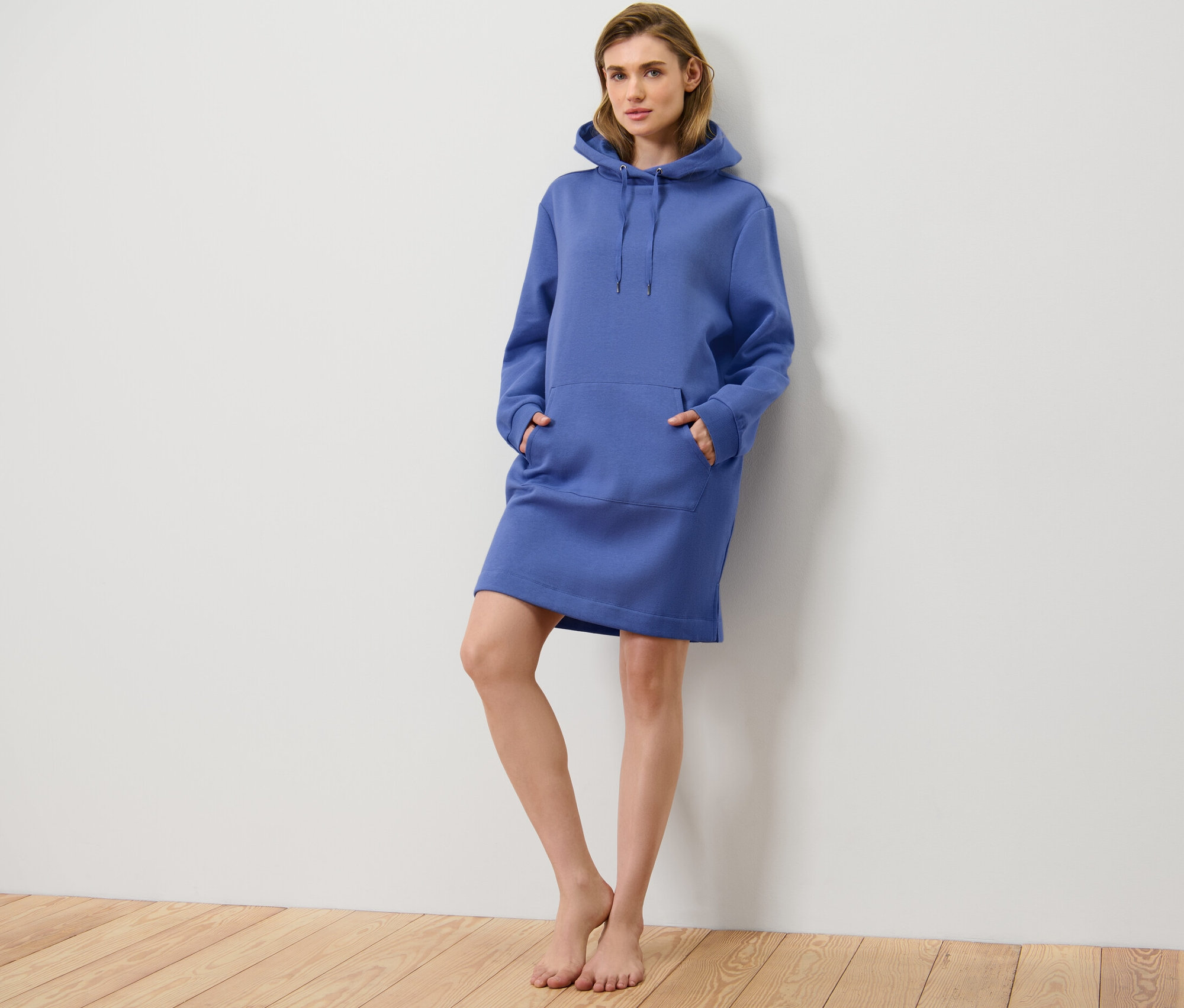 Žena pózuje v modrých voľnočasových šatách.