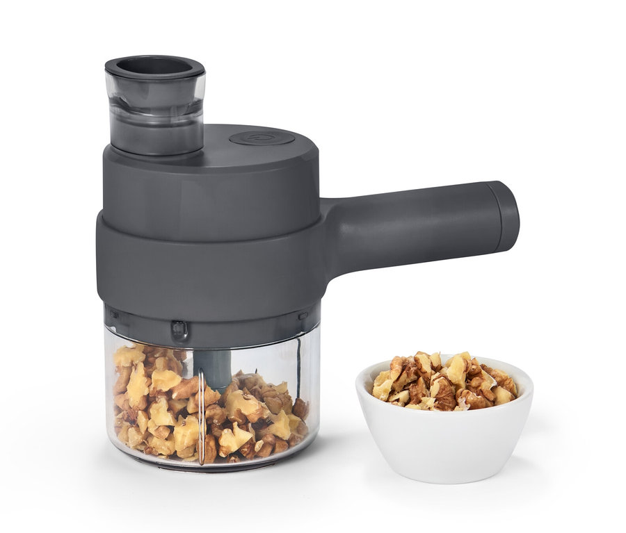 Akumulátorový multifunkčný krájač s orechmi v nádobe a miske.