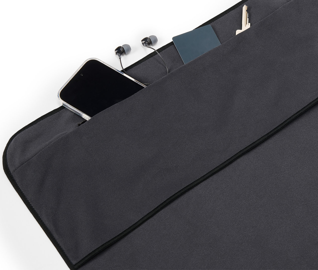 Vo vrecku z čiernej látky leží mobilný telefón, slúchadlá, karta a kľúč.