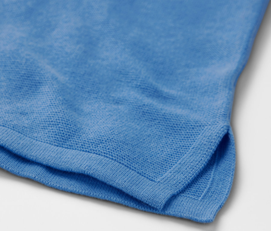 Detail svetlomodrého pleteného pulóvra.