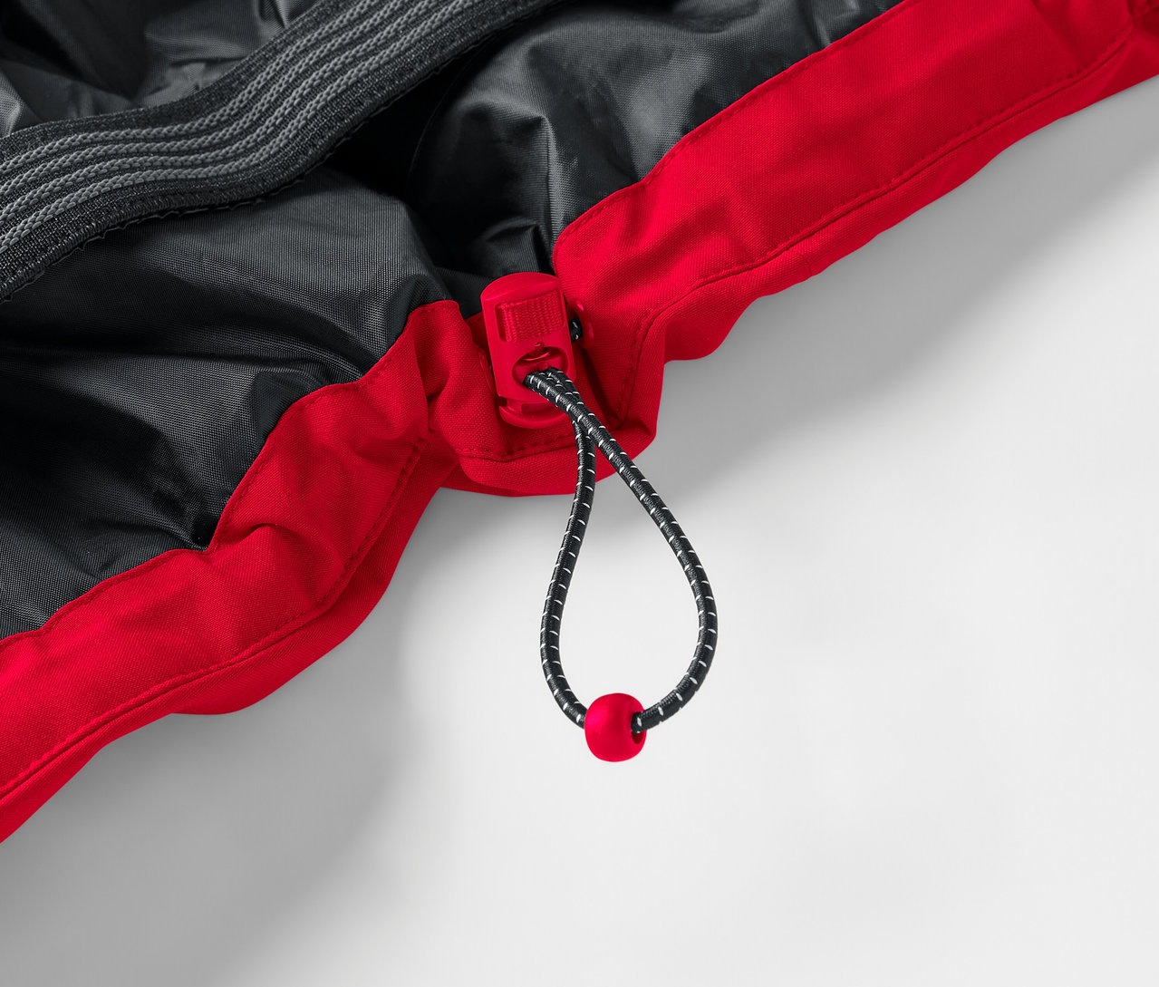 Detail červeno-čiernej bundy so sťahovacou šnúrkou.
