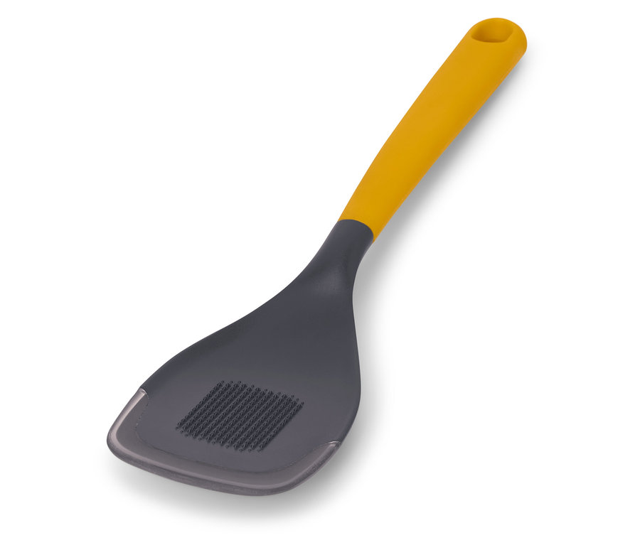 Multifunkčná vareška so žltou rukoväťou a sivou hlavou leží na bielom pozadí.