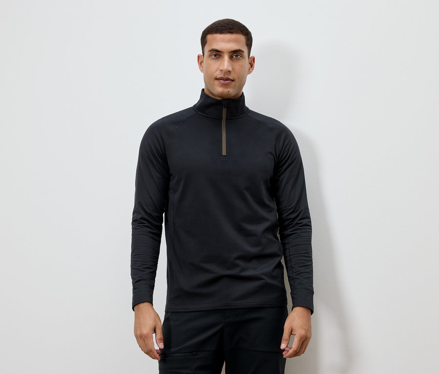 Muž má na sebe čierne tričko s dlhým rukávom a zipsom pri krku.