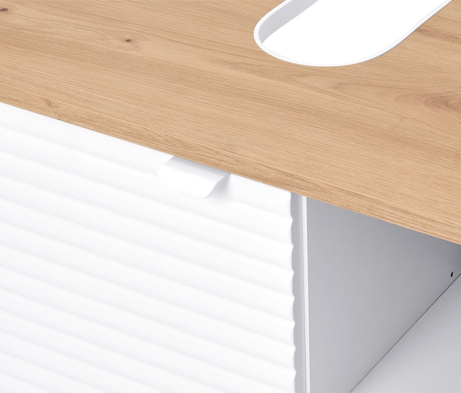 Detailný pohľad na svetlohnedý drevený stôl s bielym, ryhovaným čelom zásuvky pod ním.