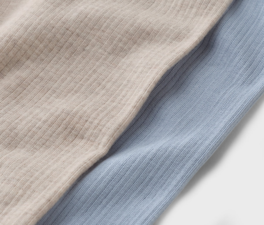Detail dvoch kusov látky: béžovej a svetlomodrej.