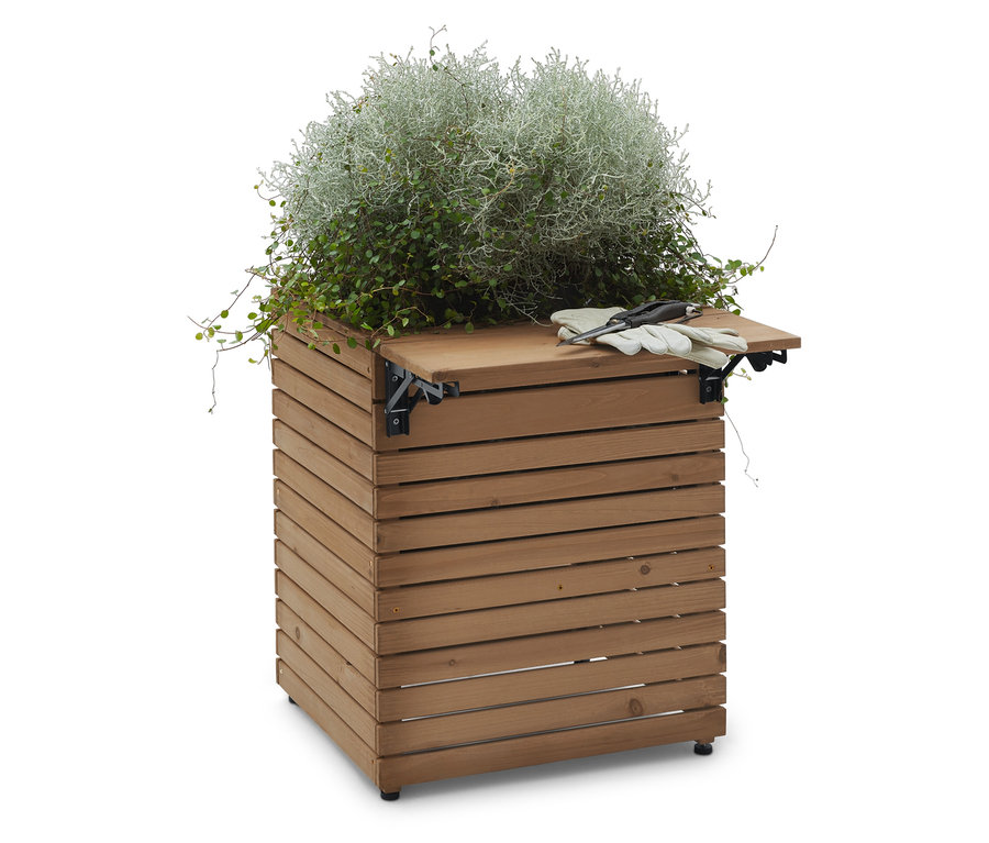 Drevená debnička na rastliny so striebornolistou rastlinou na vrchu, spolu so záhradným náradím.