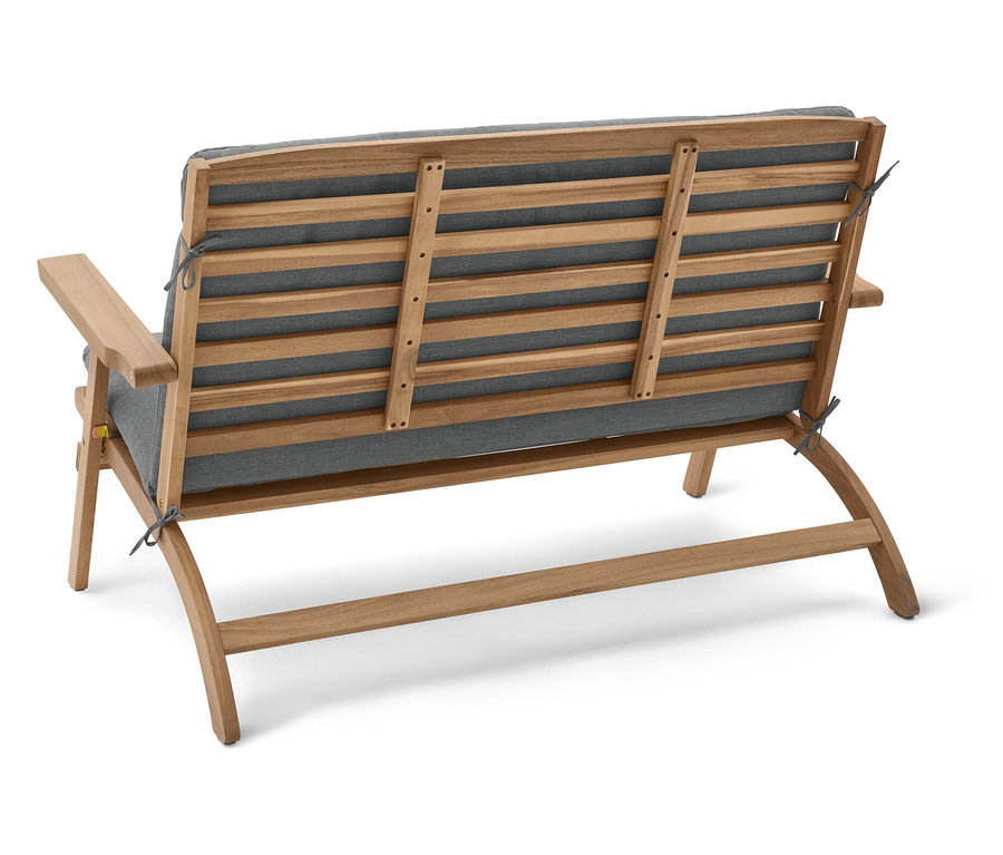 Pohľad zozadu na drevenú záhradnú lavicu so sivými poduškami.