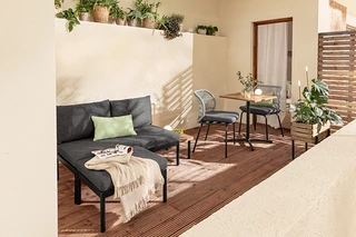 Zariadenie balkóna s variabilnou súpravou balkónového lounge nábytku Elin, stolíkom, stoličkami s textilným výpletom, 2 vankúšmi do exteriéru, kvetináčom a solárnymi zapichovacími svietidlami.
