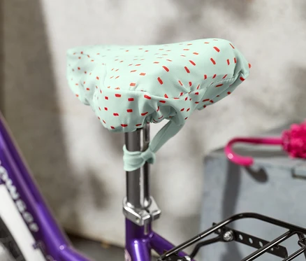 Detail fialového bicykla s poťahom na sedadlo, detský.
