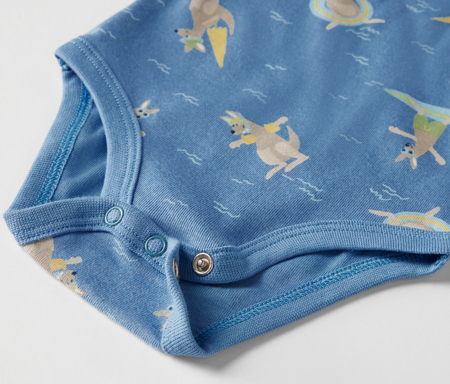 Detail modrého body s krátkymi rukávmi s potlačou klokanov.