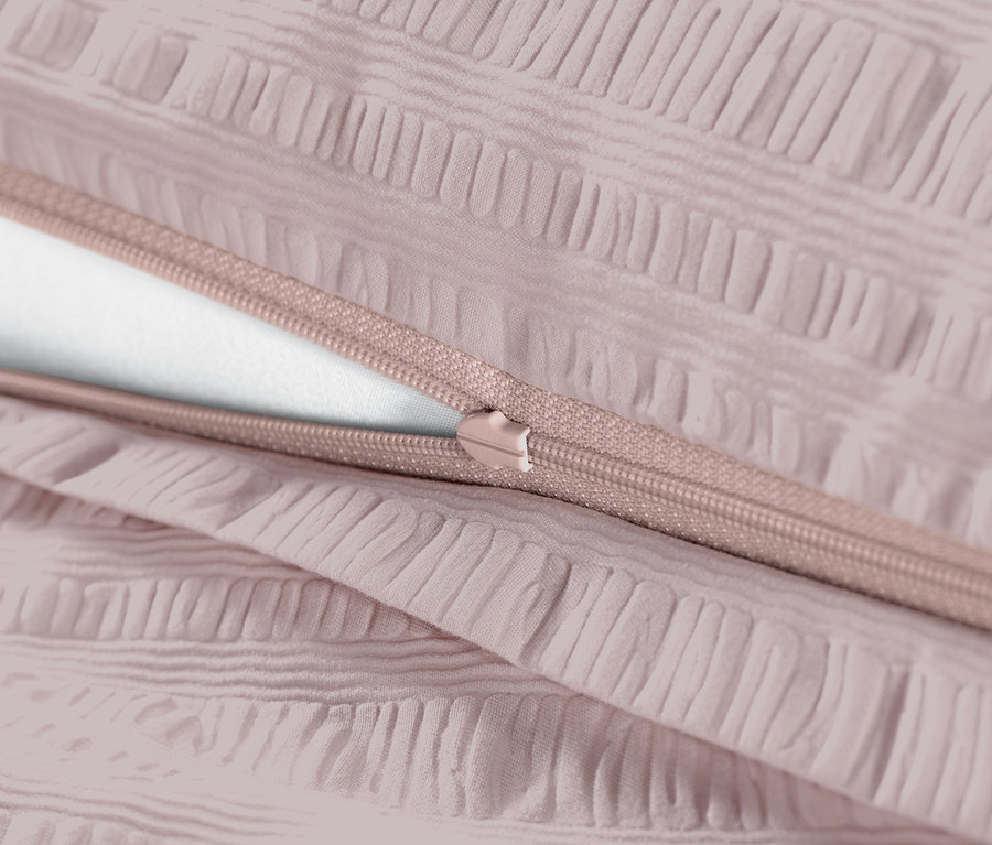 Detail ružovej krepovej posteľnej bielizne so zipsom.