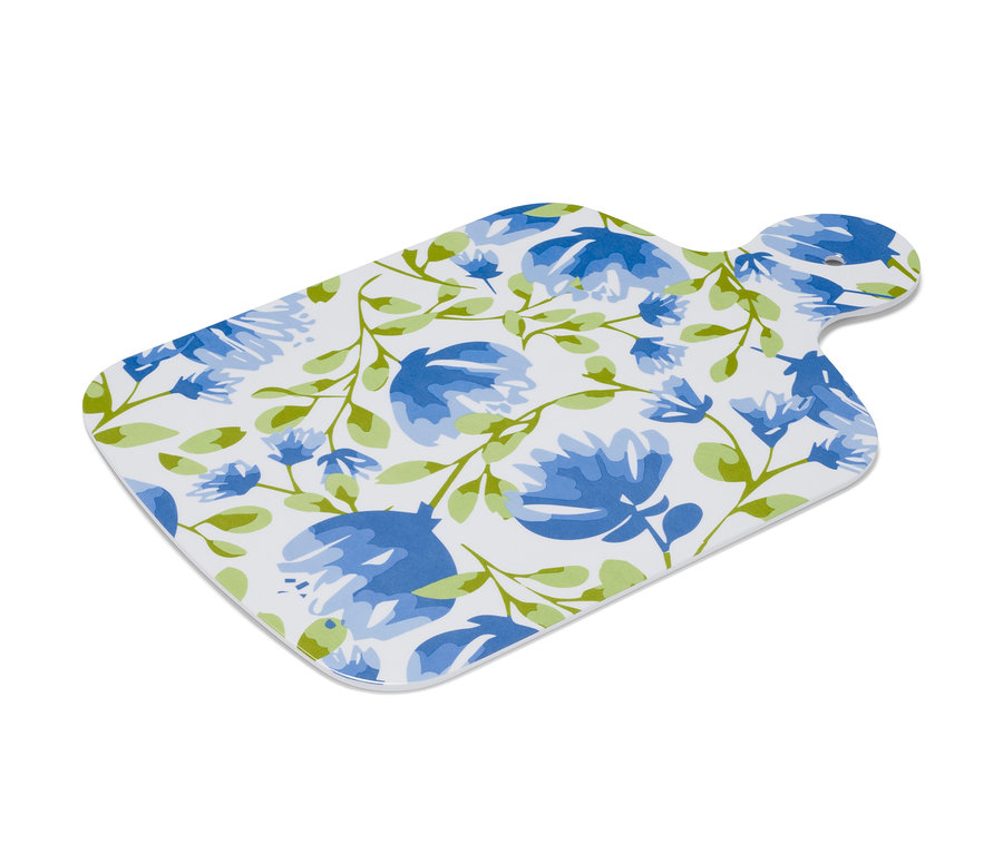 Doska na servírovanie s modrými kvetmi a zelenými listami na bielom pozadí.