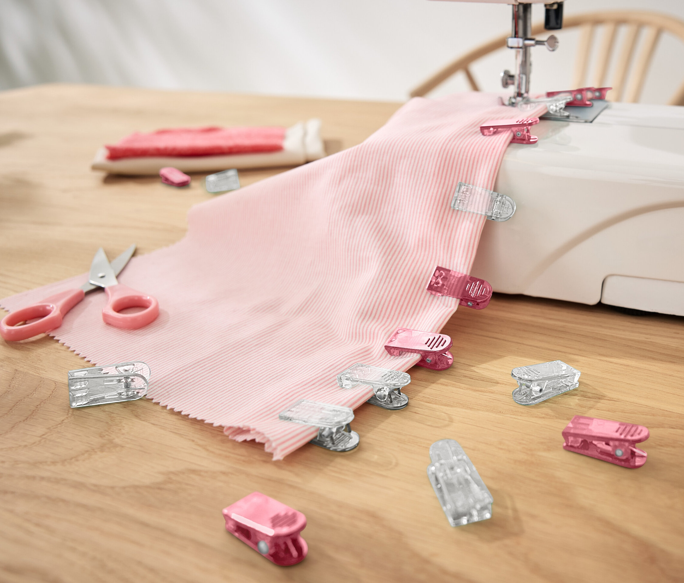 Ružová látka s 20 látkovými sponami na šijacom stroji.