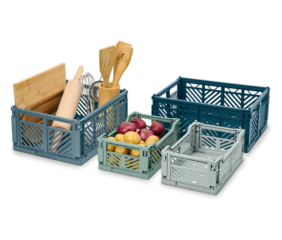 Štyri skladacie prepravky rôznych veľkostí a farieb, jedna s kuchynským náčiním, jedna so zemiakmi.