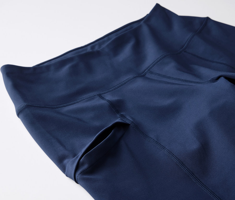 Detailný záber na 3/4 trekingové legíny tmavomodrej farby s vreckom na boku.