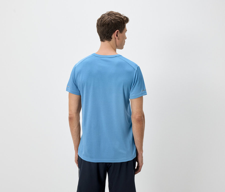 Pohľad zozadu na muža so svetlohnedými vlasmi v modrom tričku a čiernych šortkách na bielom pozadí.