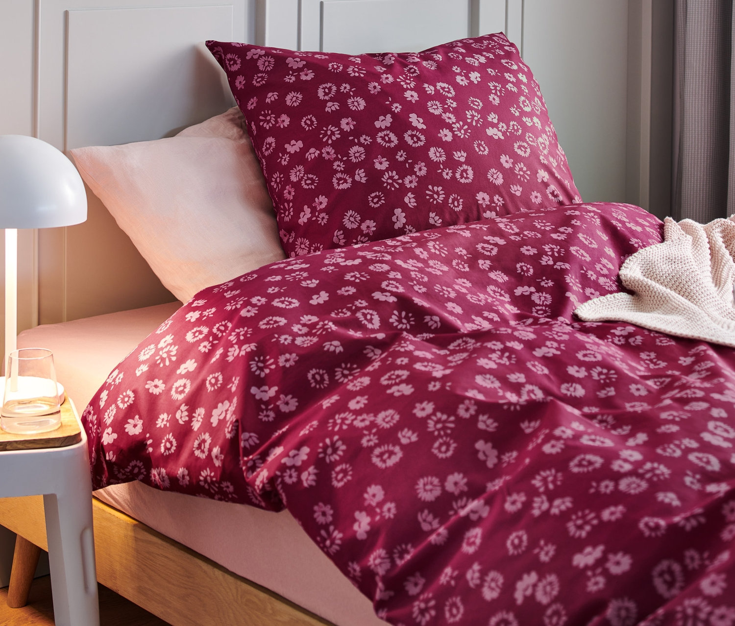 Detailný pohľad na posteľ s prémiovou bavlnenou posteľnou bielizňou s kvetinovým vzorom.