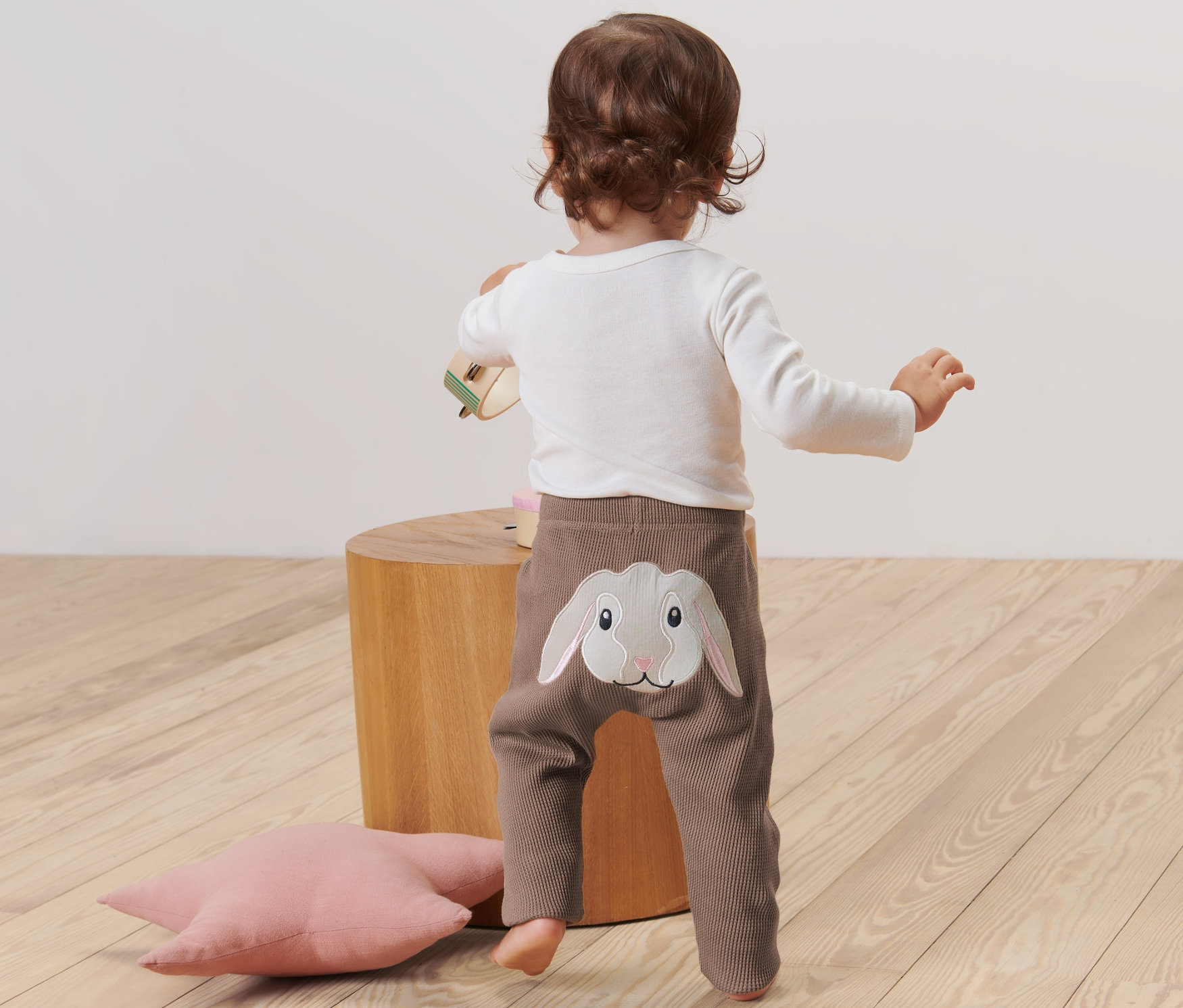 Dieťa stojí chrbtom a má na sebe detské nohavice s aplikáciou králika.