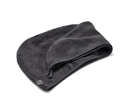 Antracitový uterákový turban leží zložený na bielom pozadí.