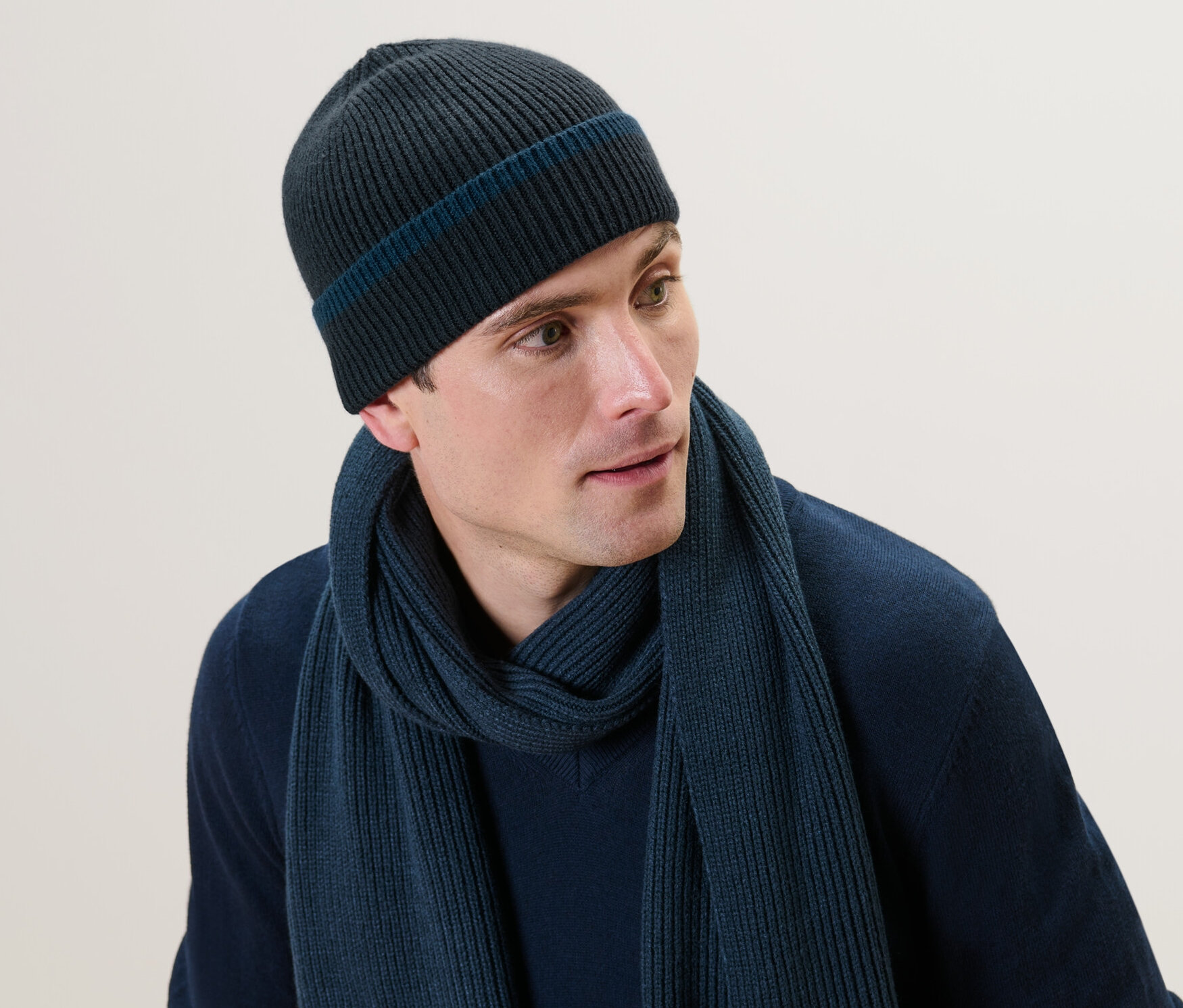 Muž má na sebe pletenú čiapku a šál.