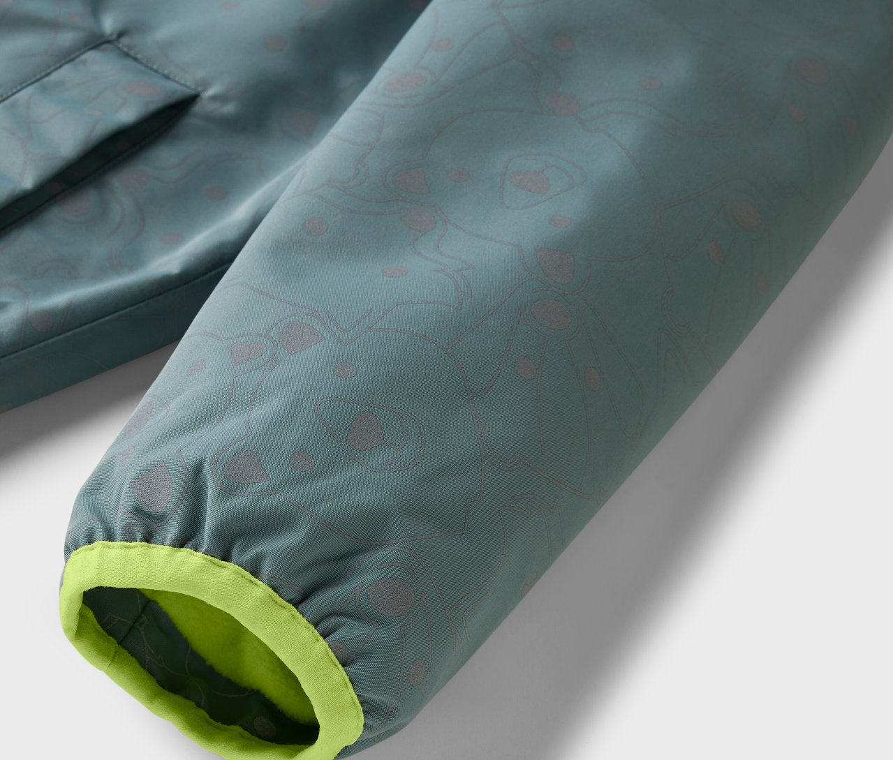 Detail detskej termo bundy do dažďa s reflexnými prvkami.