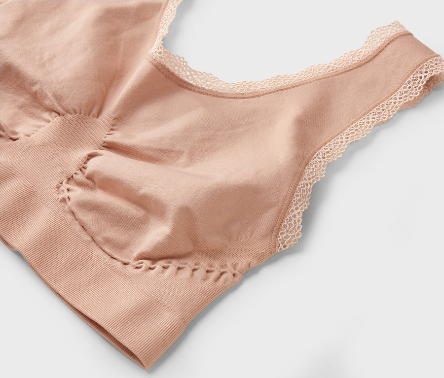 Detailný záber na telovú podprsenku s čipkou na výstrihu.