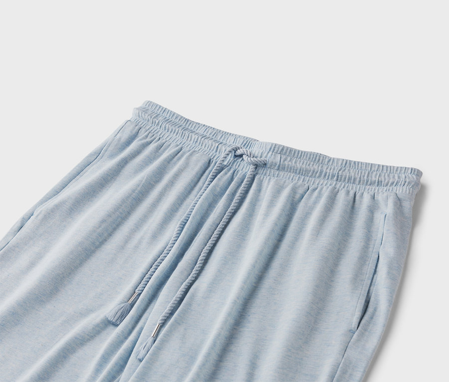 Detailný záber svetlomodrých teplákov so šnúrkou.