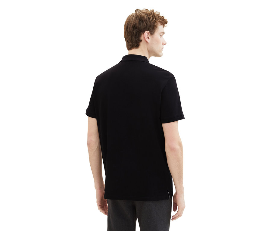 Muž zozadu v čiernej piké polokošeli Tom Tailor.