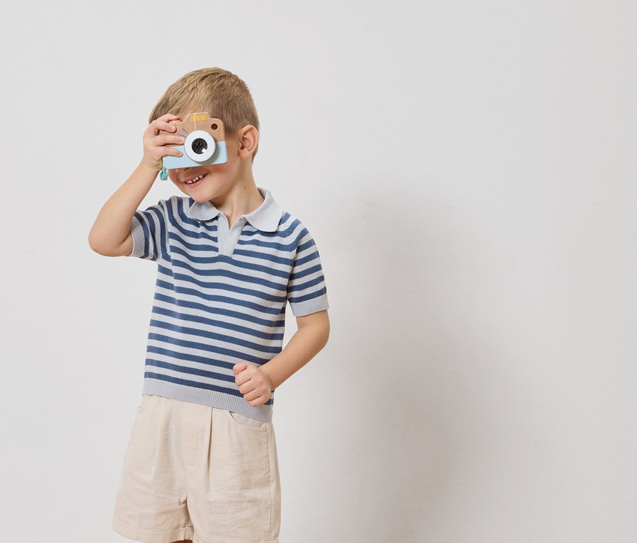 Chlapec drží hračkársky fotoaparát pred okom.