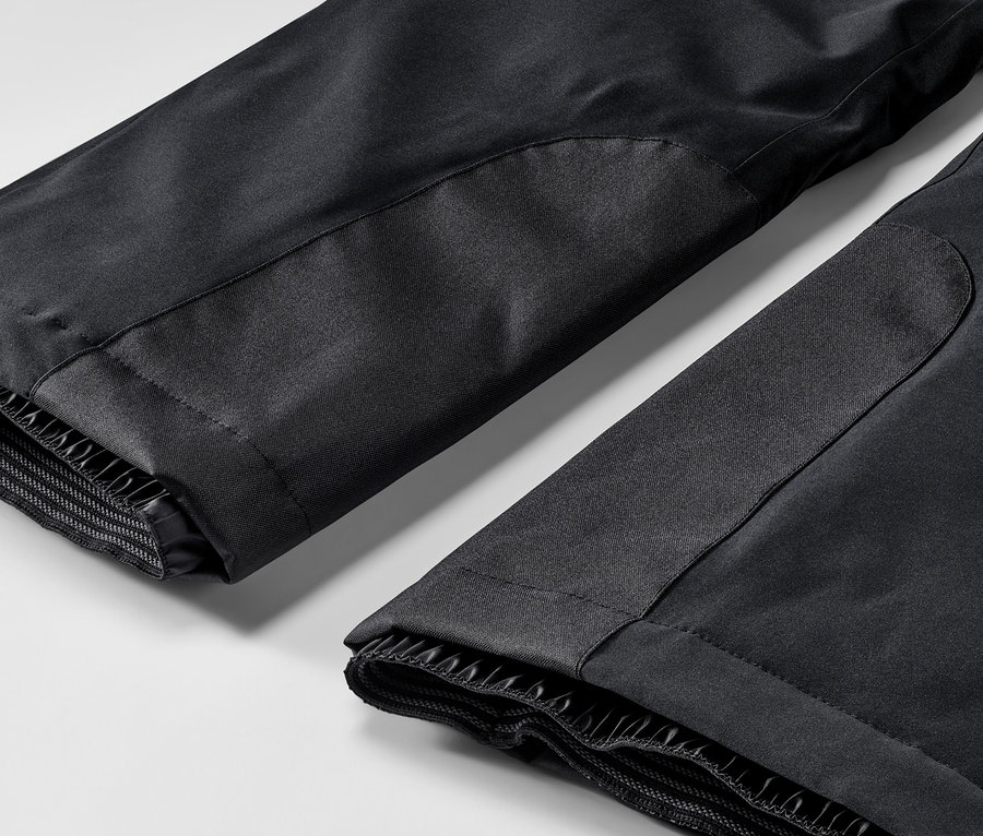 Detailný záber na čierne lyžiarske nohavice.