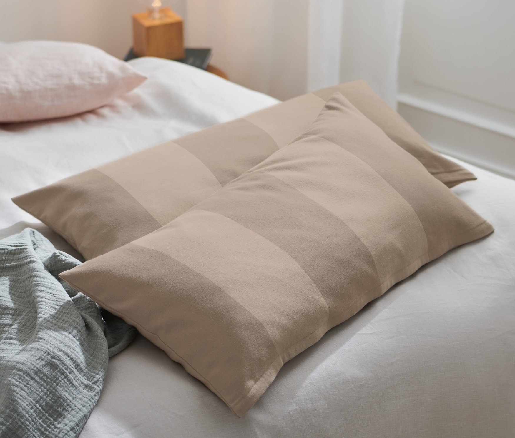 Na posteli ležia dve obliečky na vankúše z jemného flanelu.