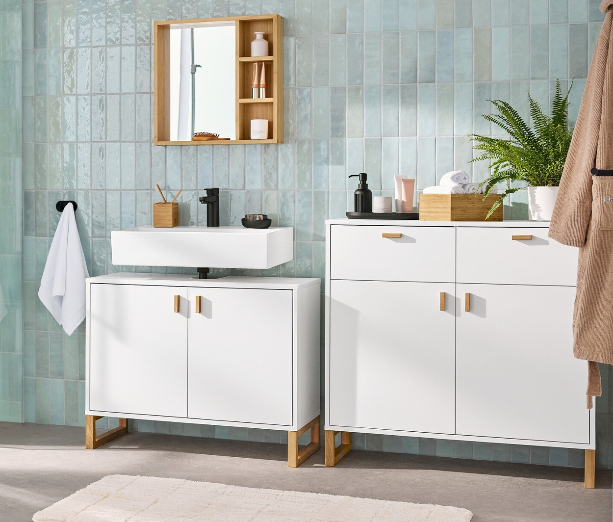 Interiér kúpeľne s umývadlovou skrinkou s 2 dvierkami, zrkadlom s odkladacími poličkami, odkladacou skrinkou s 2 zásuvkami a 2 dvierkami a vysokou kúpeľňovou skrinkou.