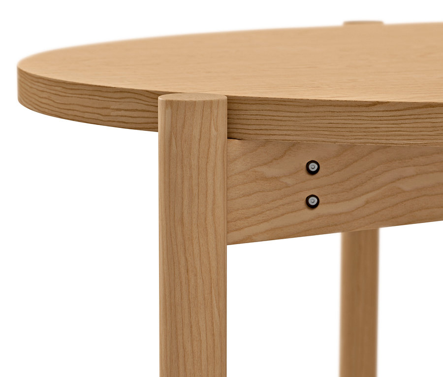 Detail okrúhleho konferenčného stolíka zo svetlého dreva s viditeľnými skrutkami.