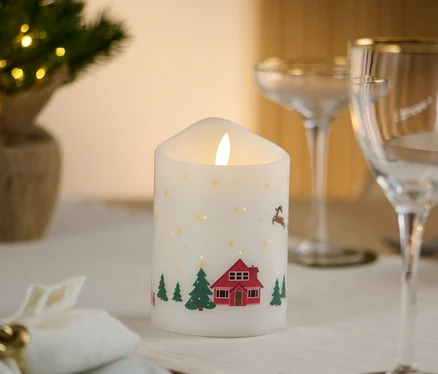 Na prestretom stole stojí LED sviečka z pravého vosku s vianočným motívom.