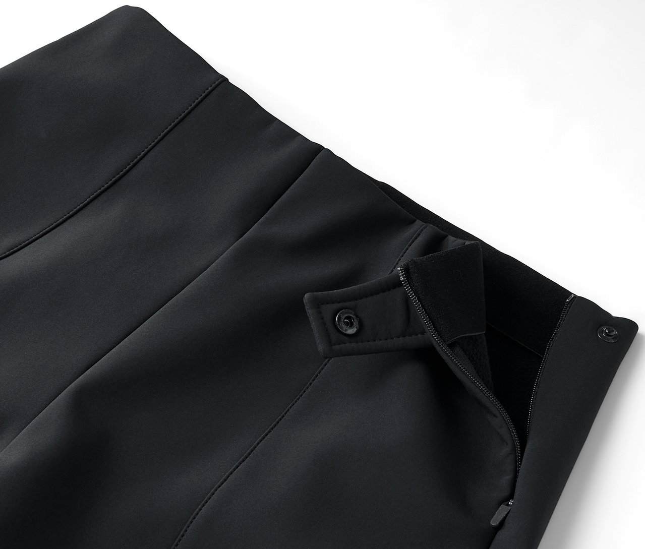 Detail čiernej sukne so zapínaním na zips a gombíky.