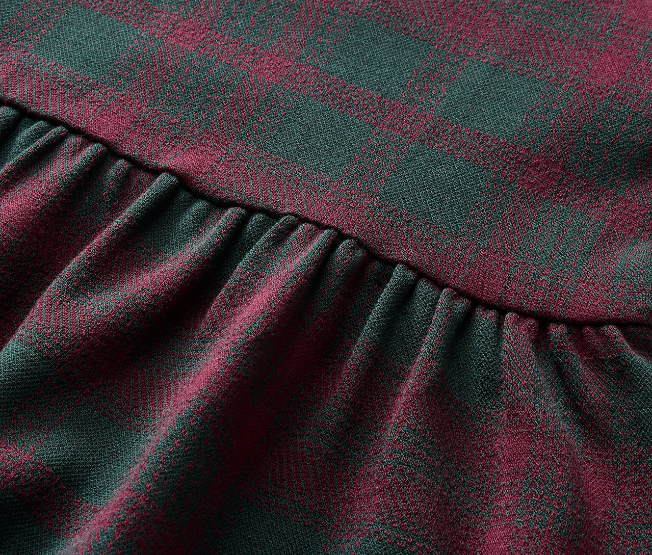 Detailný záber na látku so vzorom červeno-zelenej kocky s nariasením.