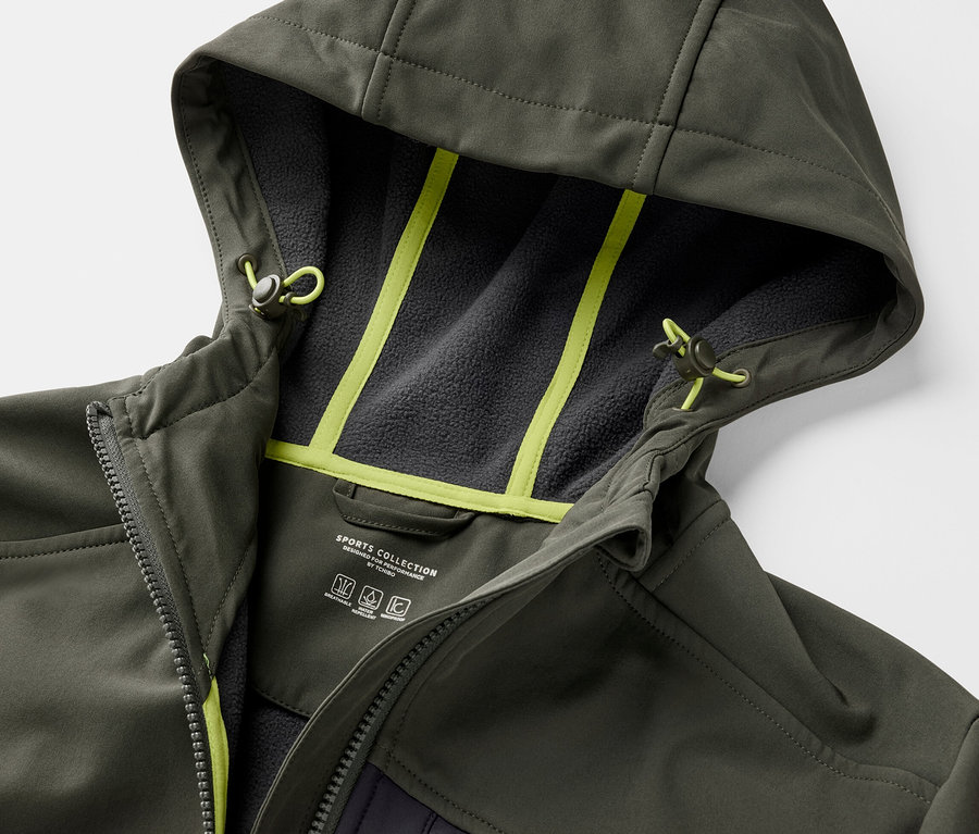 Detail khaki softshellovej bundy s kapucňou a neónovo žltými detailmi.