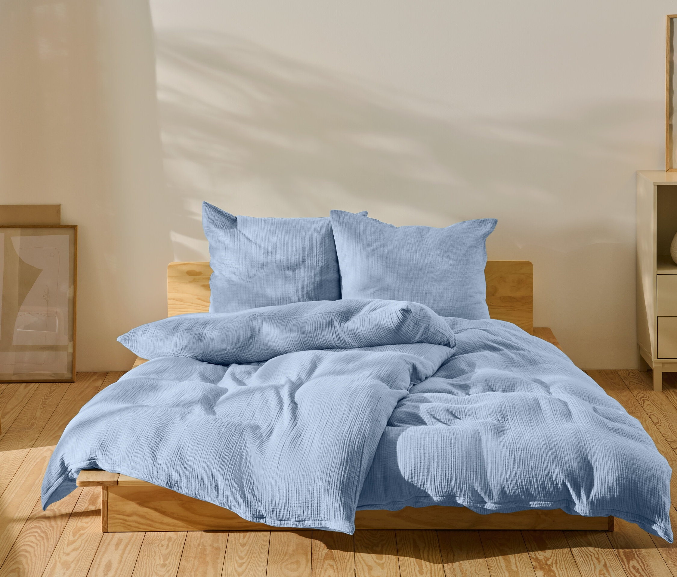 Svetlomodrá posteľná bielizeň na posteli v spálni.