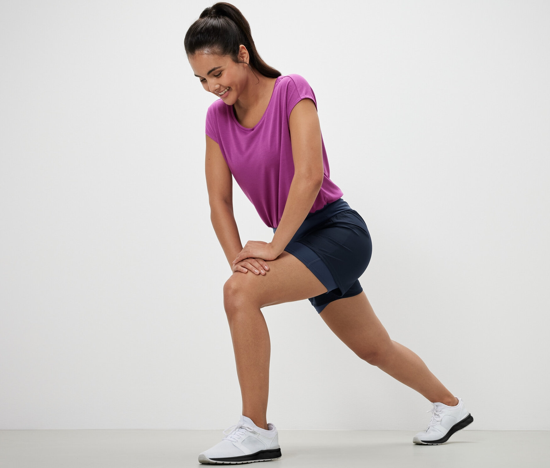 Žena sa pretahuje v bežeckých šortkách 2 v 1.