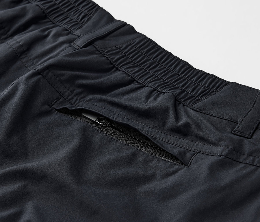 Detail čiernych funkčných nohavíc 2 v 1 s vreckom na zips.