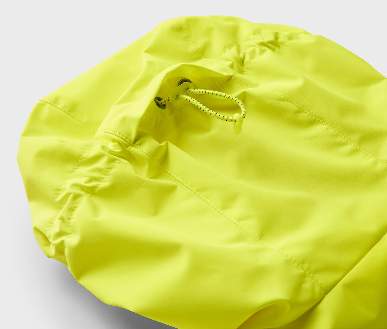 Detail žltej bundy so sťahovacou šnúrkou.