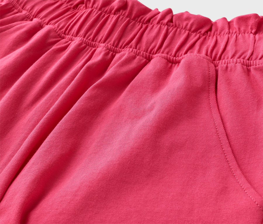 Detail ružových šortiek s elastickým pásom a vreckom.