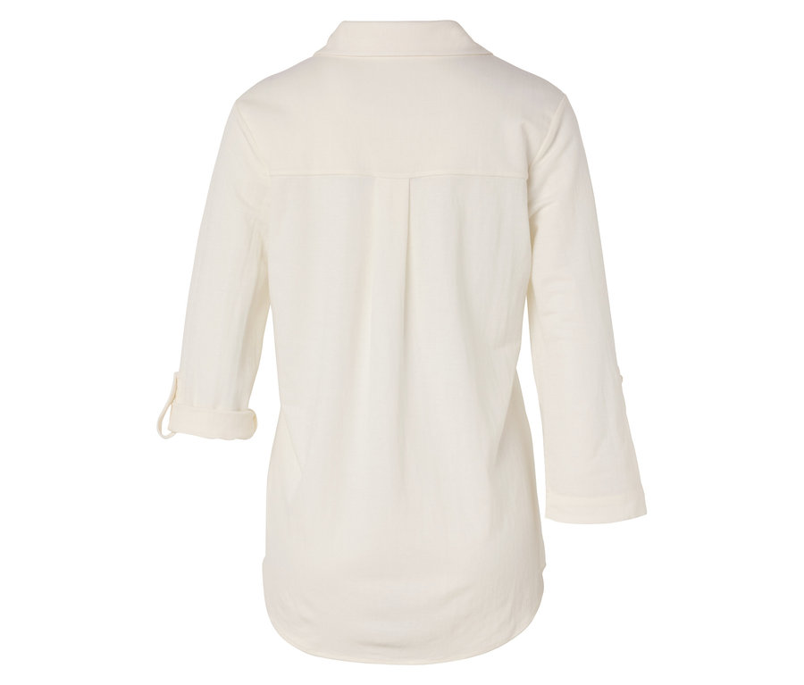 Pohľad zozadu na dlhú krémovú blúzku s vyhrnutými rukávmi.