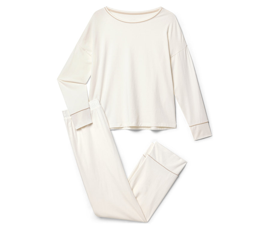 Krémové pyžamo s dlhým rukávom a nohavicami leží na bielom pozadí.